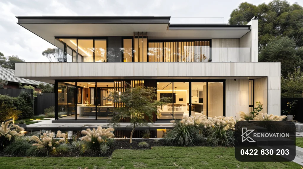 Single-storey home with a refreshed modern facade at dusk by KRenovation