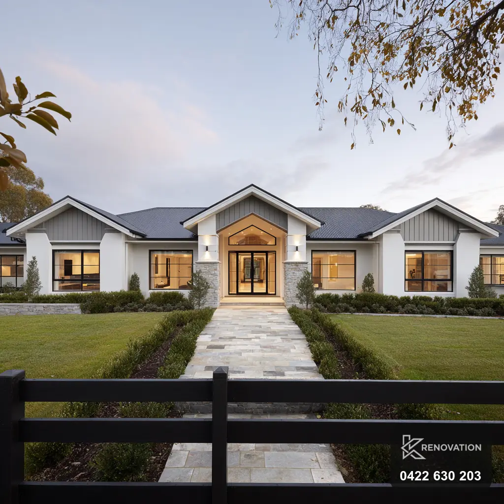 Single-storey home with a gable and lit path at dusk by KRenovation