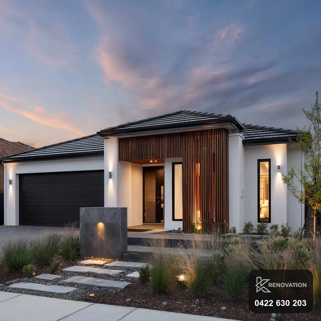 Dark timber home with a lit entry at dusk by KRenovation