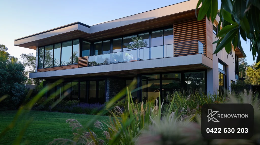 Dark and dramatic facade in dark cladding and timber at dusk by KRenovation