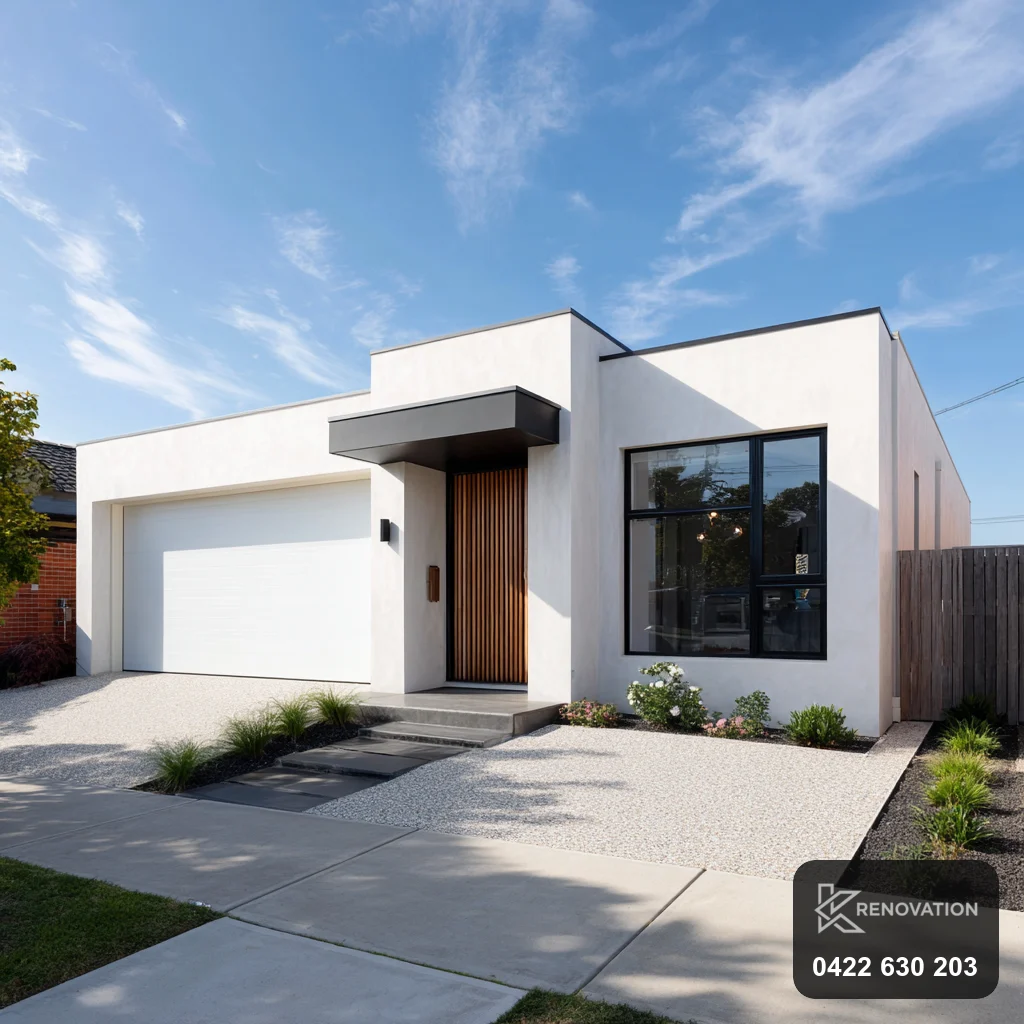 Finished facade renovation in white render and dark cladding with lawn by KRenovation
